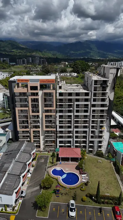 Fotografía aérea de la torre con la piscina y la cordillera al fondo